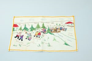 Image of Embroidered placemat with figures crossing bridge